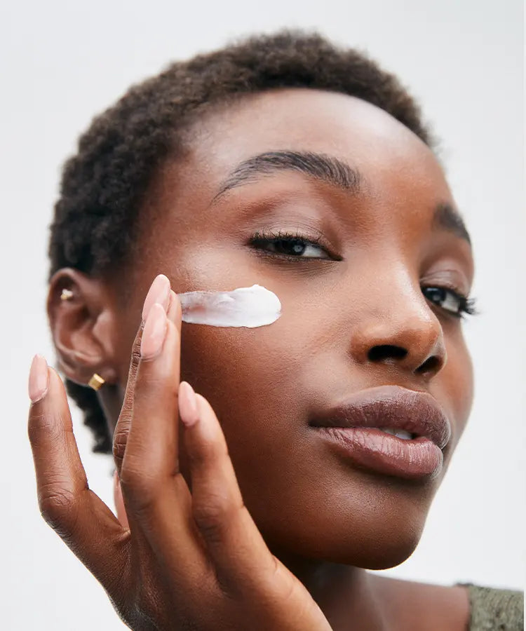 Girl using Yo Majesty Cosmetics Shea Butter cream and applying it to her face